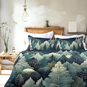 May include: A bed with a forest-themed duvet cover and pillowcases. The bedding features a detailed illustration of a forest with trees in shades of blue, green, and white. The scene is set against a dark blue background, creating a serene and natural aesthetic.