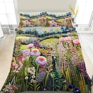 May include: A quilted bedspread and two matching pillow shams featuring a vibrant, textured print of a lush meadow filled with tall grasses, ferns, and various wildflowers in shades of pink, purple, green, and yellow under a soft sky.