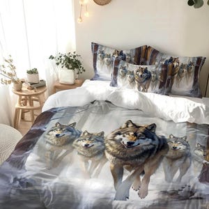 May include: A bedding set featuring a duvet cover and two pillowcases with a printed graphic of a pack of gray wolves running through a snowy forest. The wolves have detailed fur patterns in shades of gray, brown, and white, set against a winter landscape.