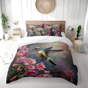 May include: A bedding set with a hummingbird design. The duvet cover and pillowcases display a colourful hummingbird with outstretched wings, surrounded by pink flowers. The set includes a duvet cover and matching pillowcases.