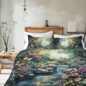 May include: A bedding set featuring a printed forest scene with a flowing stream, a small waterfall, rocks, colorful flowers, and butterflies. The design includes shades of green, blue, purple, and yellow, covering the duvet cover and pillow shams.