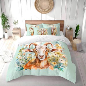 Może przedstawiać: Zestaw pościeli w stylu akwareli z kozą. Zestaw zawiera kołdrę i poszewki na poduszki z jasnozielonym tłem i kwiatowymi akcentami. Koza ma brązowo-białe futro i duże, zakrzywione rogi.