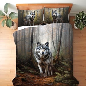 Könnte beinhalten: Bettwäsche-Set mit einem Wolf in einem Wald. Die Bettdecke und die Kissenbezüge zeigen einen grauen und braunen Wolf, umgeben von Bäumen und Blättern. Das Design verwendet eine gedämpfte Farbpalette mit Erdtönen.