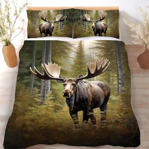 May include: A bedding set featuring a duvet cover and two pillowcases with a printed image of a large brown moose with expansive antlers standing in a dense, green, and golden forest with tall trees and lush foliage under soft lighting.
