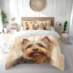 Könnte beinhalten: Bettwäsche-Set mit einem Yorkshire Terrier-Design. Das Set beinhaltet einen Bettbezug und Kissenbezüge mit einem detaillierten Porträt des Hundes. Die Farbpalette ist hauptsächlich beige, braun und grau, was eine warme und einladende Ästhetik schafft. Für ein Bett.