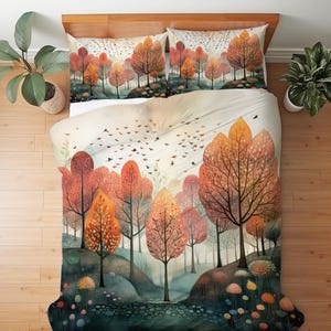 May include: A bedding set featuring a duvet cover and two pillowcases with an autumnal forest print. The design displays stylized trees with orange, red, and yellow foliage, a dark ground with small colorful circular shapes, and birds in flight.