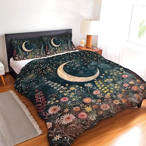 May include: A bedding set featuring a dark navy blue background with a large crescent moon and a field of colorful wildflowers. The design includes scattered stars and two matching pillowcases with a similar moon and floral pattern.