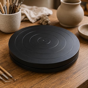 Black circular pottery turntable with concentric grooves for clay and ceramic projects