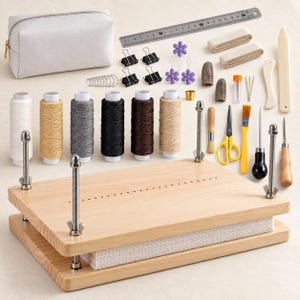 May include: A bookbinding kit featuring a light-colored wooden press with metal hardware, six spools of thread in various colors, a metal ruler measuring 30 cm, a gray zippered pouch, binder clips, flower-shaped pins, needles, and various tools.