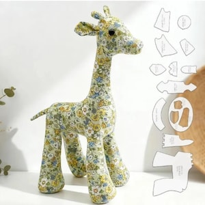 May include: A stuffed giraffe toy made from light green fabric with a repeating floral pattern in yellow, blue, and white. The giraffe has a long neck, four legs, and a tail. Beside the toy are several white paper sewing pattern templates.