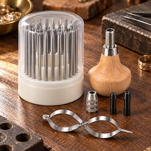 May include: A set of metal engraving tools featuring a clear cylindrical storage case filled with various steel tips, a wooden palm-grip handle with a threaded metal top, two small black collets, a silver knurled collet, and a metal ring clamp.