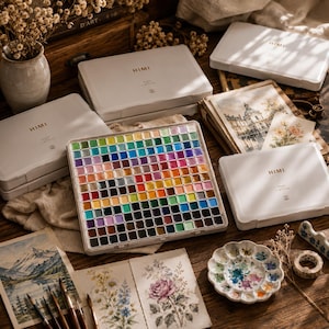 Portable watercolor paint set displayed inside a premium artist studio showing organized colors and travel-friendly design.