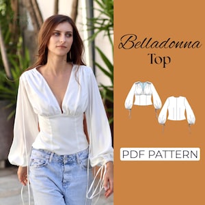 Puede incluir: Una blusa blanca de manga larga con escote en V profundo y puños fruncidos con lazos largos. La imagen incluye un dibujo técnico de la prenda y el texto Belladonna Top PDF PATTERN sobre un panel de fondo de color naranja sólido.