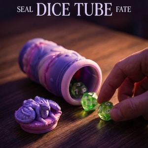 May include: A fantasy tabletop dice holder with the word "DRAGON" in large letters. The dice tube is purple and pink, with green dice inside. A small dragon seal is next to the tube. The text "SEAL DICE TUBE FATE" is also visible.