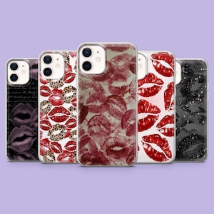 May include: Five phone cases with lip print designs. The cases feature prints of red lipstick kisses, leopard print lips, and dark lipstick prints. The cases are displayed against a light purple background.