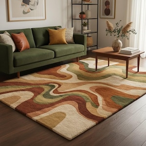 May include: A large area rug with a retro design in shades of brown, beige, and green. The rug features a wavy pattern, adding a unique touch to the living room. The rug is placed on a dark wood floor, complementing the green sofa and wooden coffee table.