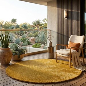 Mustard round wool area rug on balcony seating space, modern minimalist hand tufted circle rug for cozy outdoor lounge decor