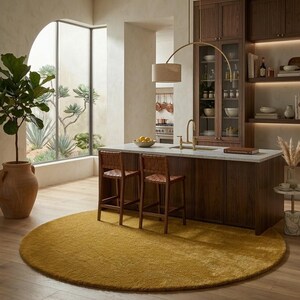 Golden round wool rug under kitchen island, handmade tufted circle carpet for modern kitchen dining space with wooden flooring