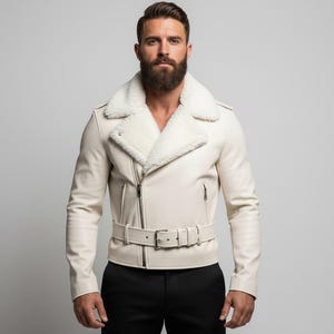 May include: Cream-colored leather jacket with a white shearling collar. The jacket features a belted waist, a zipper closure, and a classic biker style. The jacket is a neutral color and is suitable for various outfits.