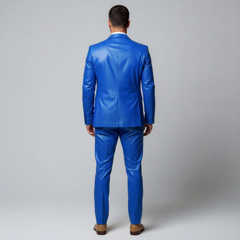 Puede incluir: Un llamativo traje de cuero azul, compuesto por una chaqueta entallada y pantalones a juego. El traje es de un color s&oacute;lido y llamativo, y la persona lleva zapatos marrones. El traje es una audaz declaraci&oacute;n de moda.