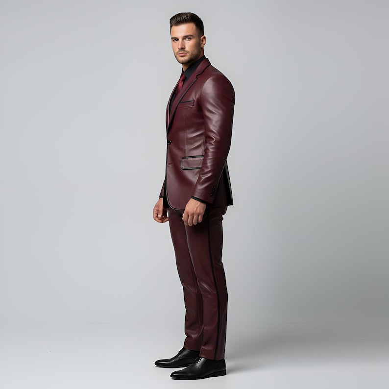 K&ouml;nnte beinhalten: Ein burgunderfarbener Lederanzug mit schwarzem Hemd und roter Krawatte. Der Anzug besteht aus einem Zweiknopf-Blazer und einer passenden Hose mit schwarzem Besatz. Schwarze Lederschuhe vervollst&auml;ndigen das Ensemble. Formelle Kleidung.