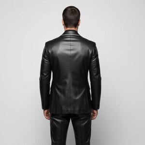 May include: A black leather suit, including a blazer and matching pants, is shown from the back. The blazer has a classic tailored fit with notched lapels and buttoned cuffs. The suit is made of a smooth, shiny leather material.