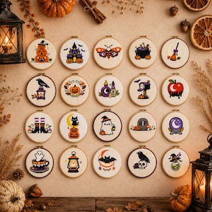 May include: A collection of twenty circular embroidery hoops featuring various Halloween-themed designs, including pumpkins, ghosts, bats, a black cat, a cauldron, a crystal ball, and a haunted house, all displayed in a grid on a neutral background.