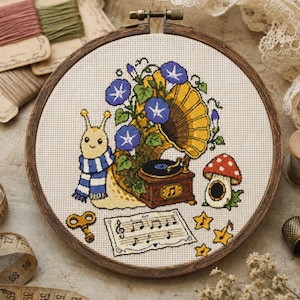May include: A cross-stitch embroidery in a circular wooden hoop featuring a cream-colored snail wearing a blue and white striped scarf, a vintage gramophone with blue morning glory flowers, a red and white mushroom house, a key, and sheet music.