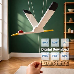 Könnte beinhalten: Ein Holz-Vogelmobile mit weißen Flügeln, schwarzen Flügelspitzen, einem roten Kopf und gelbem Schnabel. Das Mobile wird an Schnüren aufgehängt. Das Bild enthält auch den Text "Digital Download" und Dateityp-Symbole.