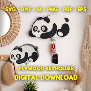Könnte beinhalten: Ein panda-förmiger Schlüsselhalter aus Sperrholz in Weiß und Schwarz, mit Schlüsseln daran. Der Schlüsselhalter ist an einer weißen Wand befestigt. Der Text "PLYWOOD KEYHOLDER" und "DIGITAL DOWNLOAD" wird in Gelb angezeigt. Das Bild enthält auch den Text "SVG - DXF - AI - PNG - PDF - EPS".
