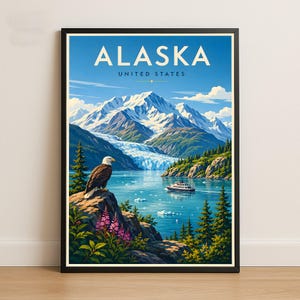 May include: A framed travel poster featuring the text ALASKA UNITED STATES. The illustration depicts a bald eagle perched on a rocky cliff with pink wildflowers, overlooking a blue glacial bay with a cruise ship and snow-capped mountains.