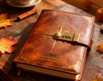 Può includere: Un diario in pelle marrone con un design a bussola e una serratura a combinazione. Il diario è personalizzato con il nome "Liam" e una citazione. Accenti dorati adornano gli angoli. Una tazza di tè e foglie d'autunno sono sullo sfondo.