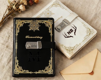 May include: Two leather password diaries, one black and one white, with gold decorative borders. The black diary has a combination lock and the text "Password diary". The white diary has a combination lock and the initials "NB".