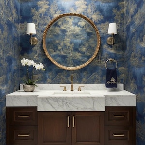 May include: A bathroom vanity featuring a marble countertop, dark wood cabinets, and a gold-framed mirror. The walls are adorned with blue and gold scenic wallpaper. Two wall lights flank the mirror, and an orchid sits on the counter.