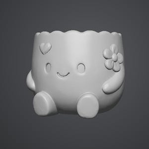 Puede incluir: Una maceta blanca y redondeada con una cara sonriente, detalles de coraz&oacute;n y flores. La maceta tiene dos brazos peque&ntilde;os y dos pies. El borde superior tiene un dise&ntilde;o festoneado.