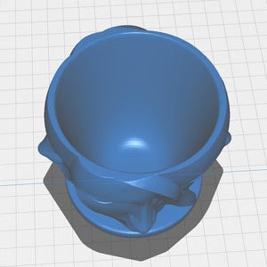 May include: A 3D-printed blue decorative bowl with a floral design. The bowl has a round base and a wide opening. The floral design is on the sides of the bowl. The bowl is made of plastic.