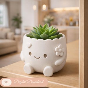 Peut inclure: Un pot de plante en céramique blanche avec un visage souriant, des détails de cœur et de fleur, contenant une plante succulente verte. Le pot a une forme arrondie avec de petits pieds. Le texte "Digital Download" est en bas.