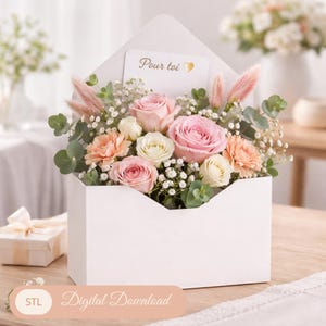 Könnte beinhalten: Ein weißer, umschlagförmiger Blumenstrauß gefüllt mit rosa und weißen Rosen, pfirsichfarbenen Nelken und Grünzeug. Eine Karte mit dem Text "Pour toi" ist sichtbar. Die Anordnung befindet sich auf einer Holzoberfläche.