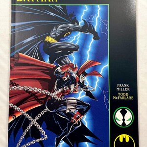May include: A comic book titled Spawn Batman by Frank Miller and Todd McFarlane. The cover features Batman and Spawn against a blue lightning background. The Image Comics logo is at the bottom, with Spawn and Batman circular emblems on the right.