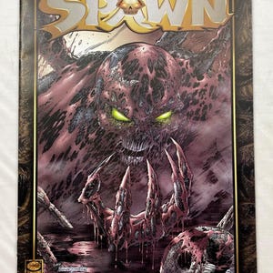 May include: Comic book cover for "Curse of the Spawn" No. 1. The artwork features a monstrous figure with glowing green eyes, a skull-like face, and large, clawed hands emerging from a dark, bloody environment. The title "Spawn" is prominently displayed.