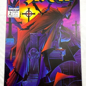 May include: Spawn comic book cover featuring a figure in a red cloak against a purple and yellow background. The title "Spawn" is in large, stylized letters. The Image Comics logo and issue number 2 are visible.