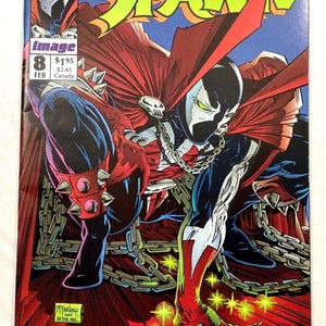 May include: Spawn comic book cover featuring a dynamic illustration of the character in a red cape and spiked gauntlets. The cover includes the title "Spawn" in green and the issue number 8, with the artist's signature "McFarlane After Me."