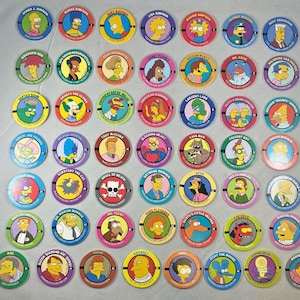 May include: A collection of forty-eight circular cardboard pogs featuring colorful illustrations of various characters from The Simpsons. Each disc displays a character portrait, their name, and a unique background color, arranged in a grid pattern.