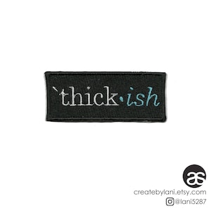 May include: Black embroidered patch with white text that reads "thick.ish" in a cursive font. The "ish" is in a light blue colour.