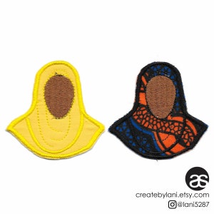 May include: Two embroidered fabric patches depicting a person wearing a headscarf. One patch is yellow with a brown face, the other is blue, orange, and black with a brown face.
