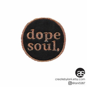 May include: A black circular patch with gold embroidered text that reads "dope soul."