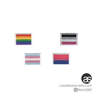 Peut inclure: Quatre patchs brodés à repasser représentant différents drapeaux de la fierté : arc-en-ciel, transgenre, lesbien et bisexuel.