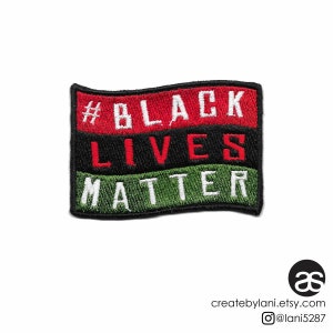 Peut inclure: Patch brodé "Black Lives Matter" avec un motif de couleurs rouge, noir et vert. Le patch est rectangulaire et a un bord légèrement ondulé.
