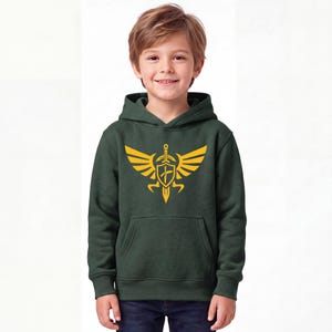 May include: A dark forest green hooded sweatshirt featuring a large, bright yellow graphic print on the chest. The design depicts a stylised emblem consisting of a central shield and sword flanked by two symmetrical, feathered wings.