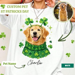 May include: White t-shirt with a custom St. Patrick's Day design featuring a golden retriever wearing a green shamrock headband and sweater. The dog's name, "Charlie," is printed below. The shirt also has the text "CUSTOM PET ST PATRICKS DAY".